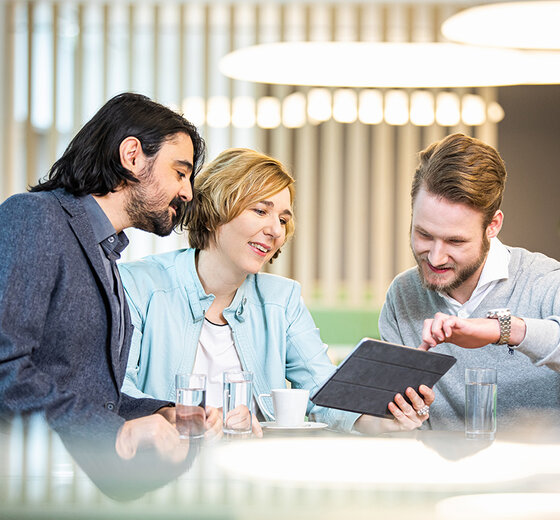 Three team members interested in something on an iPad