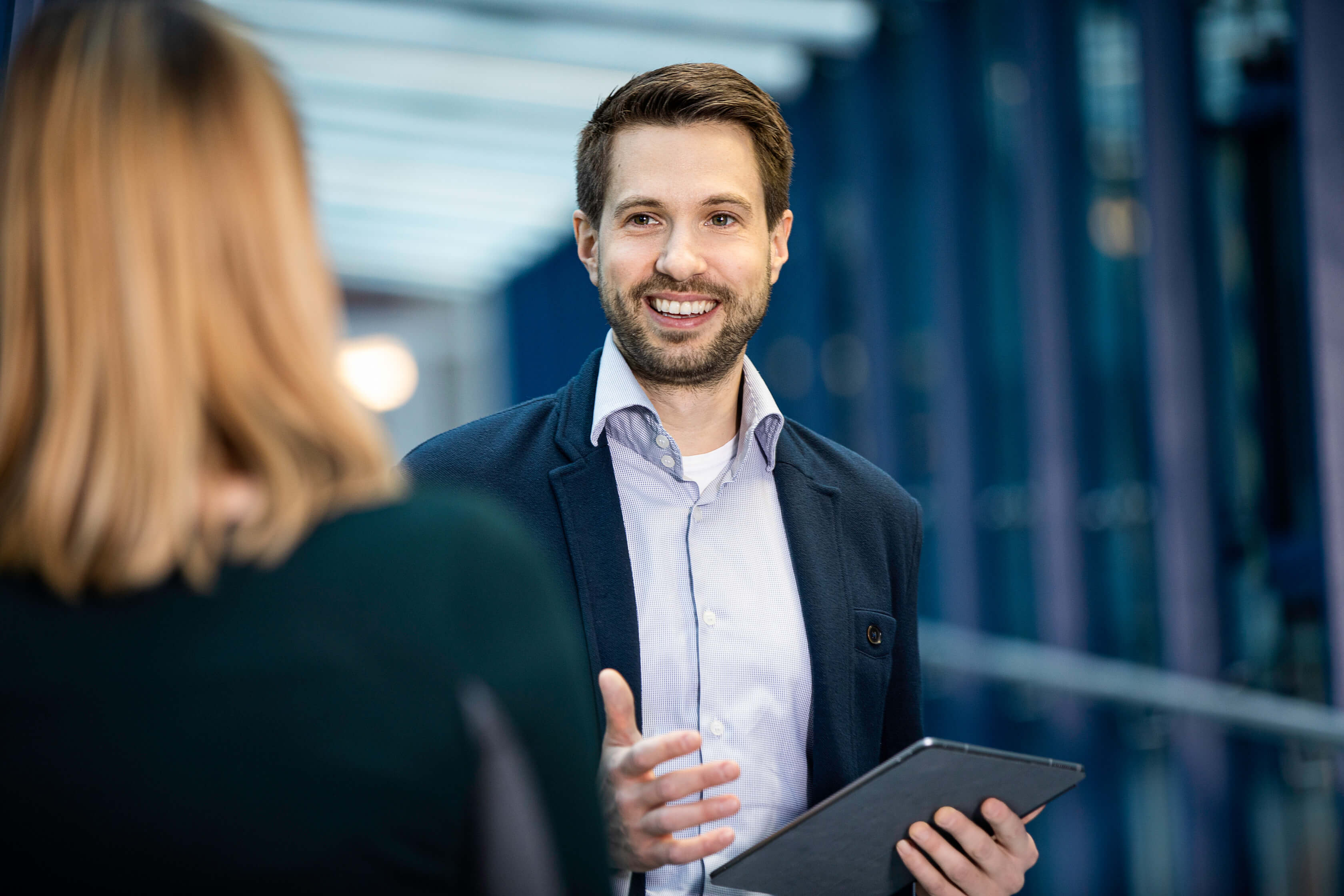 Employee smiling in conversation with a colleague